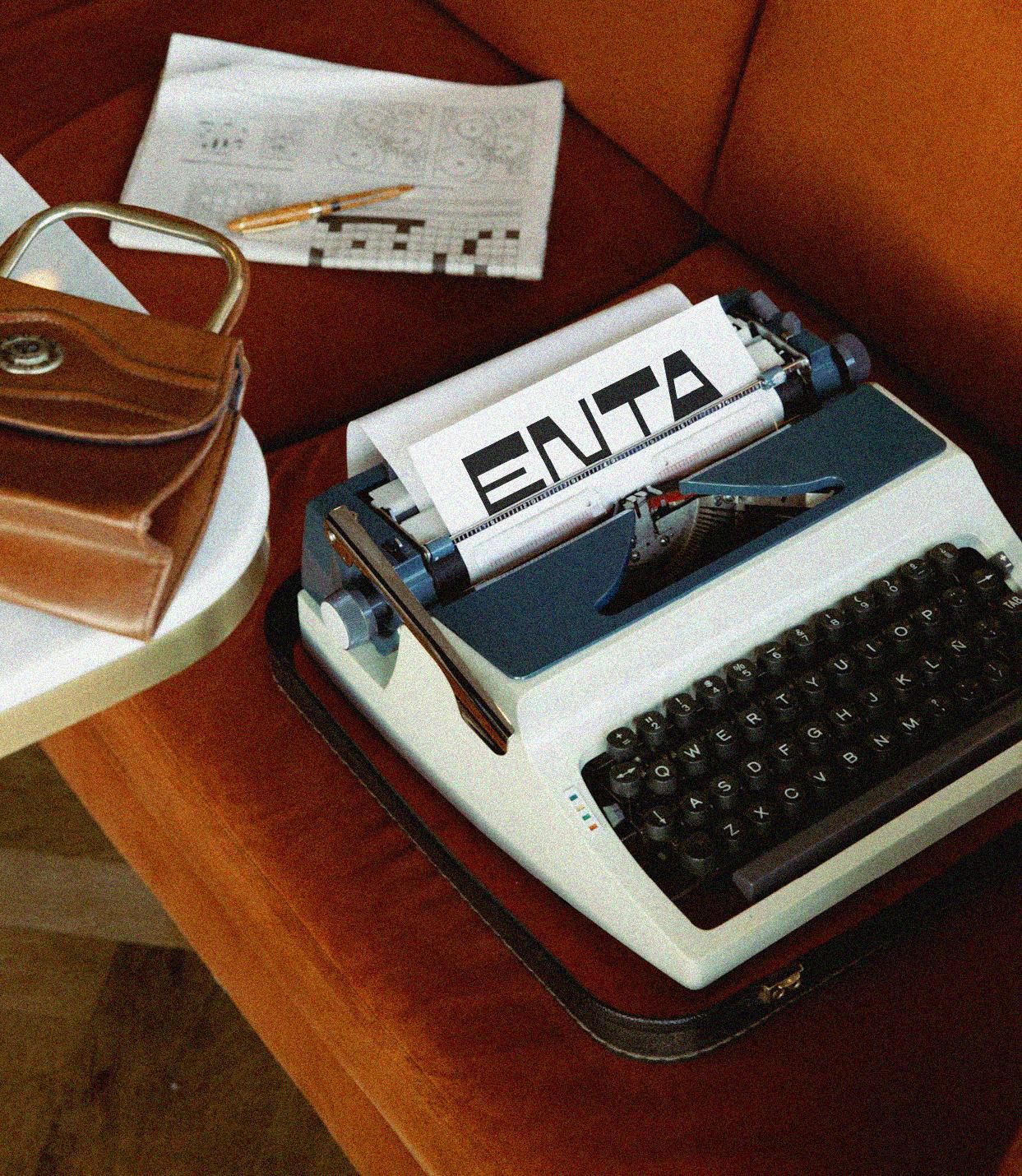 Sun setting over a calm, wavy ocean under a hazy, pinkish sky.